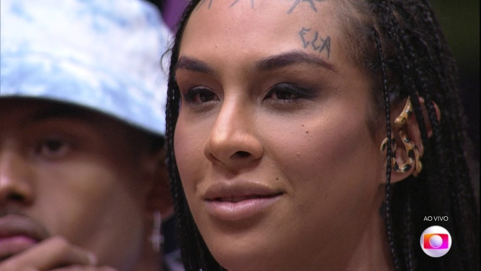 Linn da Quebrada no BBB22. Cantora tem o pronome feminino 'ela' tatuado no rosto (Foto: Reprodução/Globo)