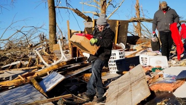 Moradores de Mayfield, Kentucky, tentam resgatar pertences dos escombros após tornados que estão entre os mais devastadores da história dos EUA (Foto: REUTERS via BBC)