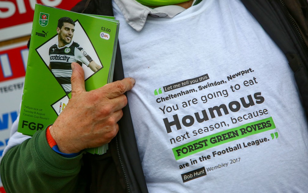 Torcedor exibe camiseta que provoca times adversários com a inscrição ‘vocês terão que comer houmous na próxima temporada porque o Forest Green Rover está na Football League’ (Foto: Geoff Caddick/AFP)