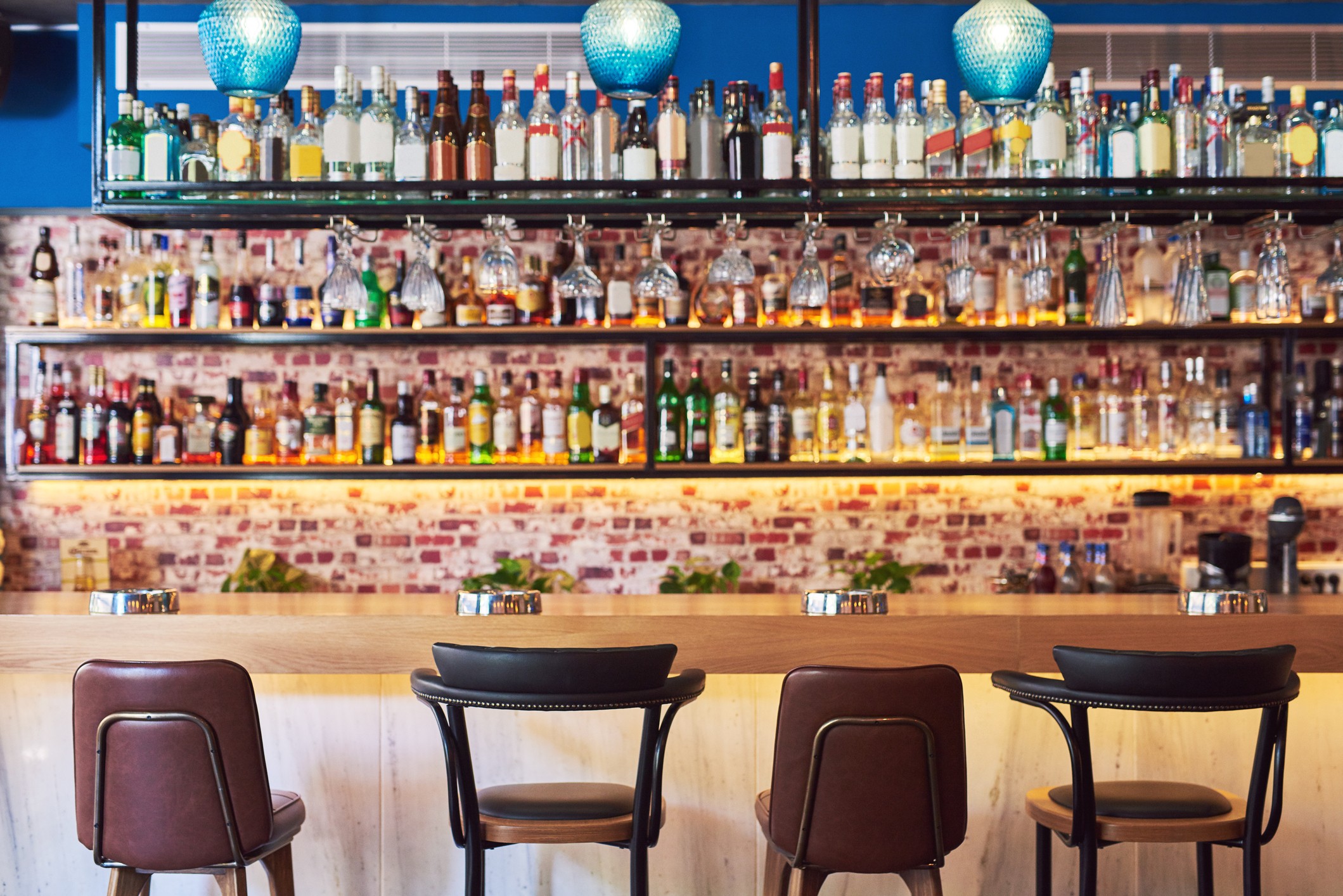 Shot of an immaculate bar with many bottles and glasses with no people (Foto: Getty Images)