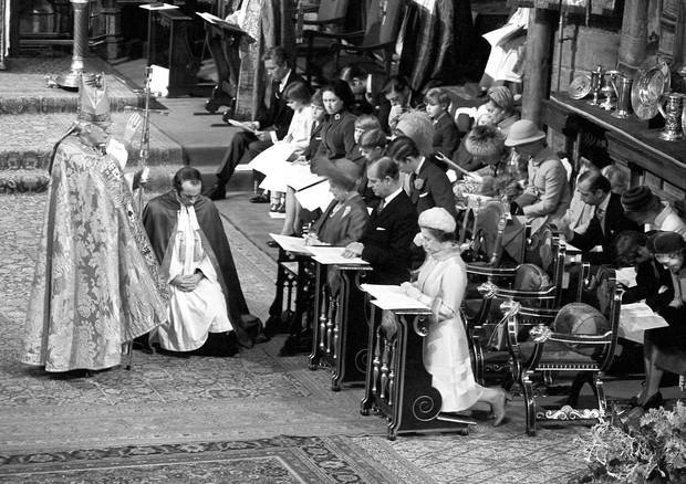 On her knees in prayer, The Queen, with The Duke of Edinburgh and The Queen Mother in Westminster Abbey during the Thanksgiving Service for their Silver Wedding Anniversary. Dr Michael Ramsey, Archbishop of Canterbury (left) is shown giving the Blessing. (Foto: PA Archive/PA Images)