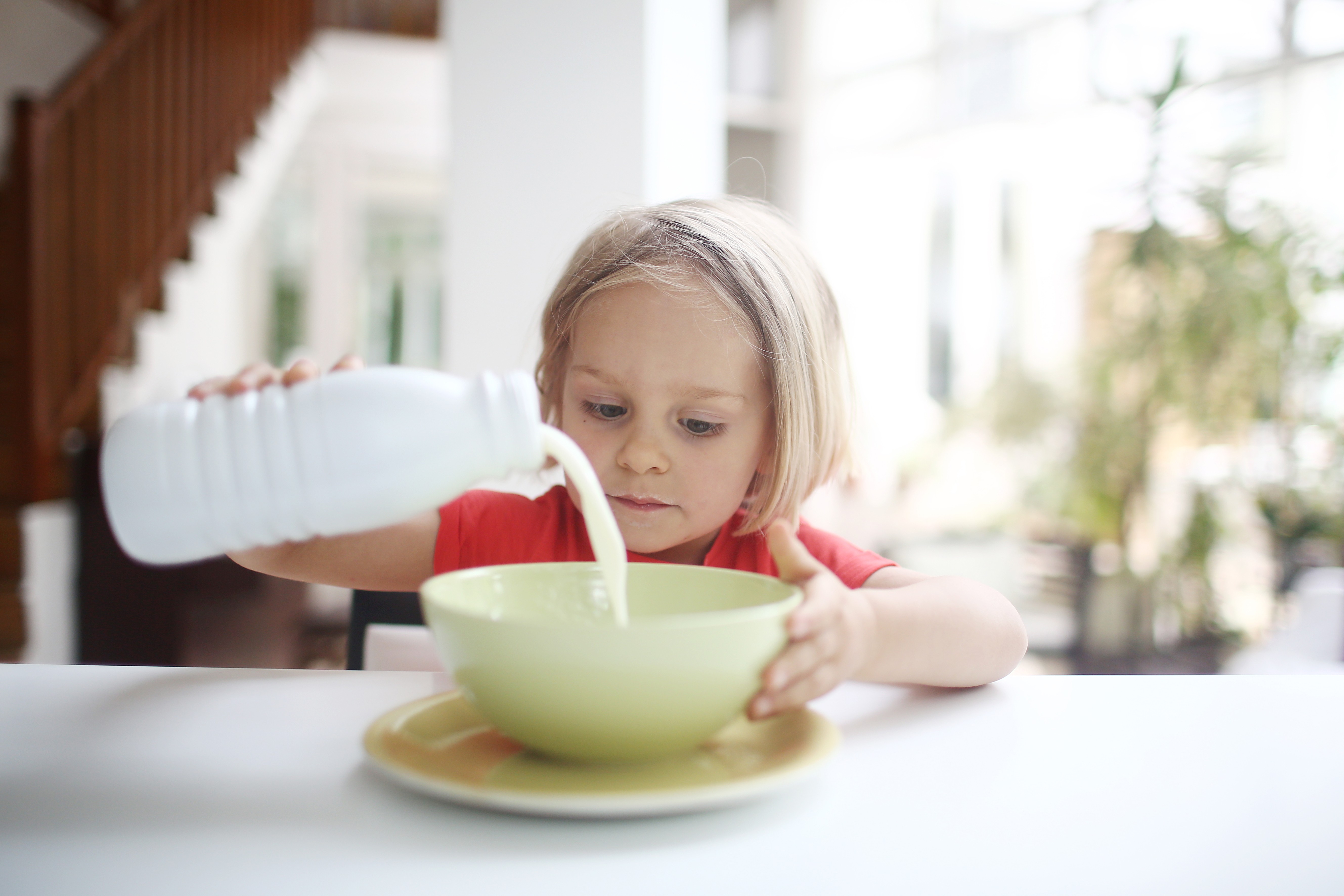 Criança despejando leite em vasilha (Foto: Getty Images)