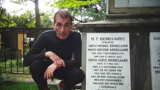 Ele já visitou mais de 700 cemitérios em diversos países; na imagem, ele visita memorial a Kierkegaard — Foto: Reprodução