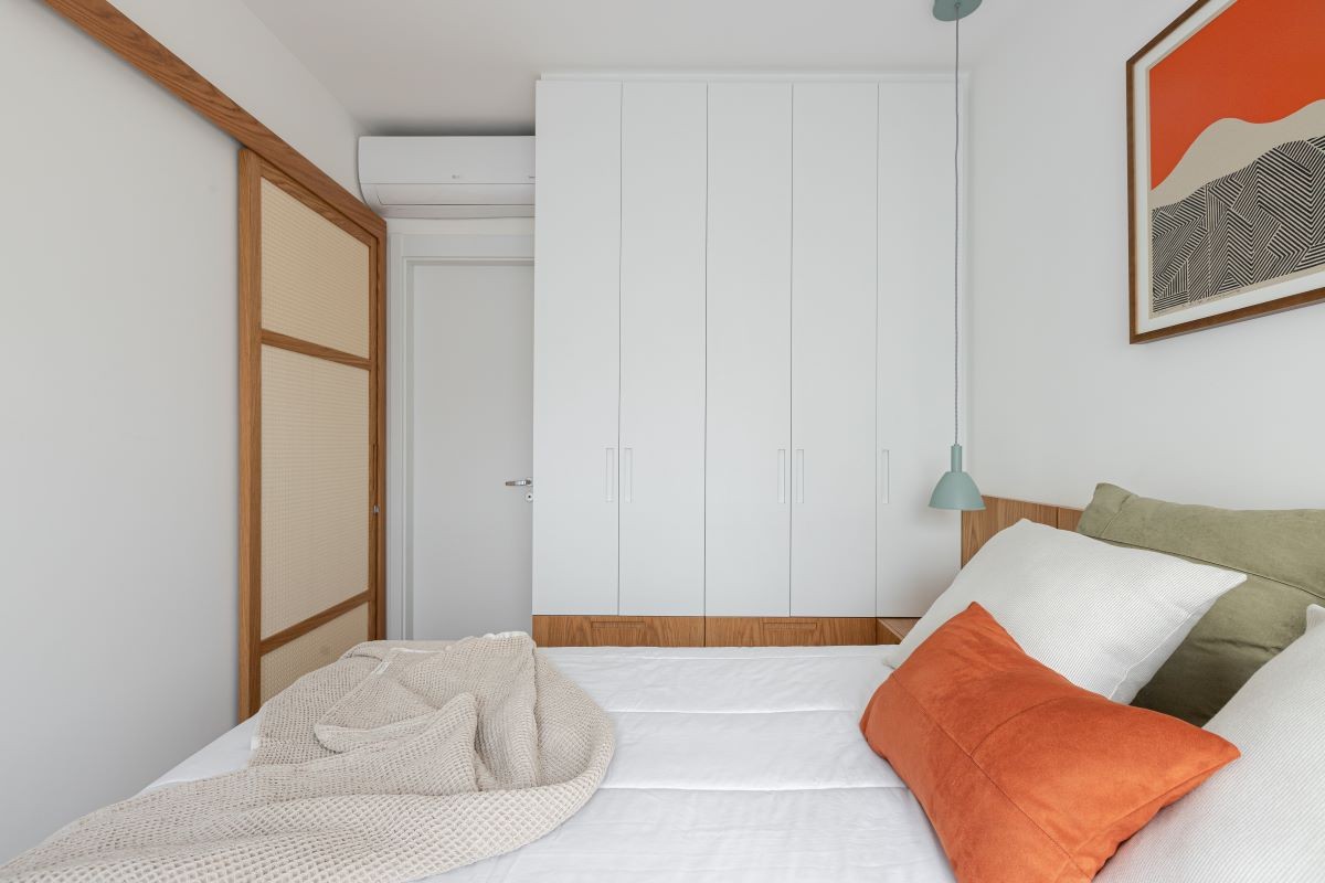 SUÍTE | Composta principalmente por branco, madeira e palhinha, o quarto é o ambiente mais aconchegante do projeto. Marcenaria é assinada pela Made Marchi e pendente 