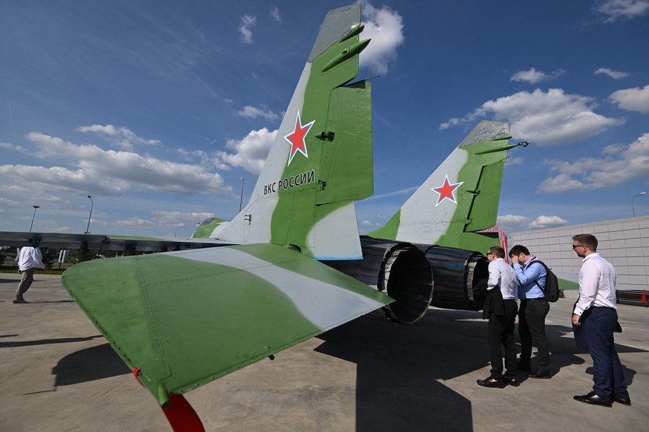 Visitantes examinam caça russo MiG-29 em feira de armas em Moscou