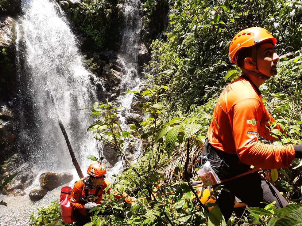 Socorristas descem por paredão lateral à cachoeira — Foto: GRM/Divulgação