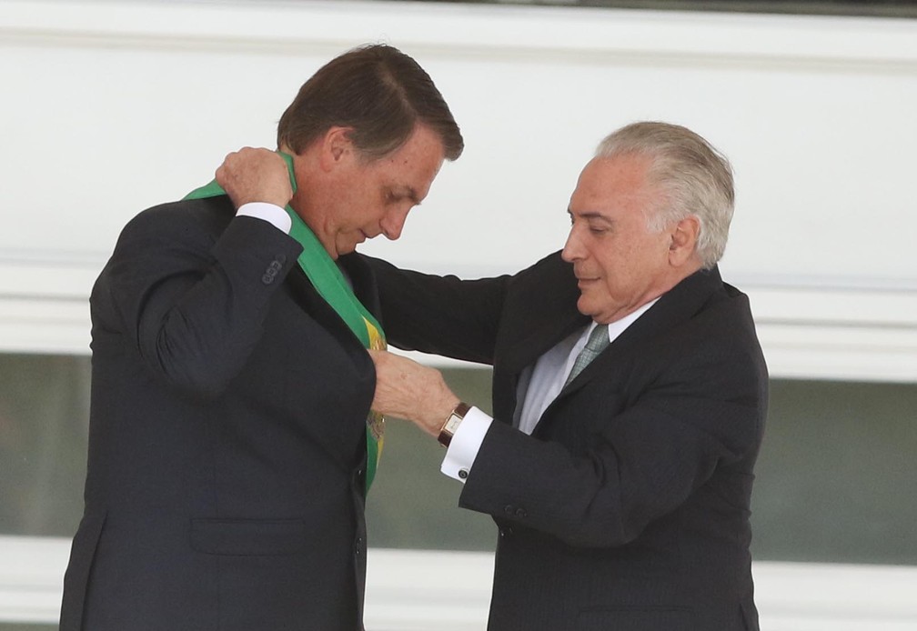 O ex-presidente Michel Temer transmite a faixa presidencial para o presidente empossado Jair Bolsonaro, no Palácio do Planalto, em Brasília — Foto: Célio Messias/Estadão Conteúdo