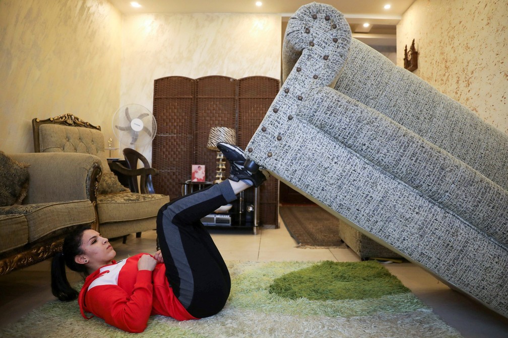 Hadeel Alami, praticante de judô da Jordânia, usa o sofá como parte de seus treinamentos em sua casa durante o isolamento imposto pelo governo para evitar a propagação da doença por coronavírus (COVID-19) em Amã, na Jordânia — Foto: Muhammad Hamed/Reuters