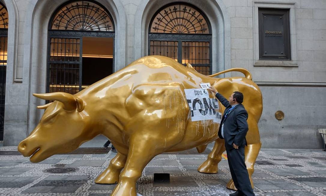 Estátua do touro dourado amanhece com adesivo de protesto contra a fome no lombo (Foto: Reprodução)