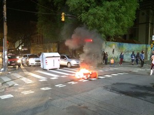 Ao final de caminhada, pequeno grupo colocou fogo em lixo e bloqueou rua (Foto: Estêvão Pires/RBS TV)