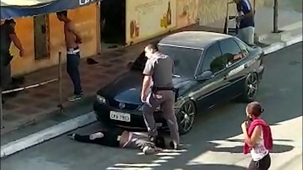 PM pisa no pescoço de mulher negra para imobilizá-la em Parelheiros, na Zona Sul de SP — Foto: Reprodução TV Globo