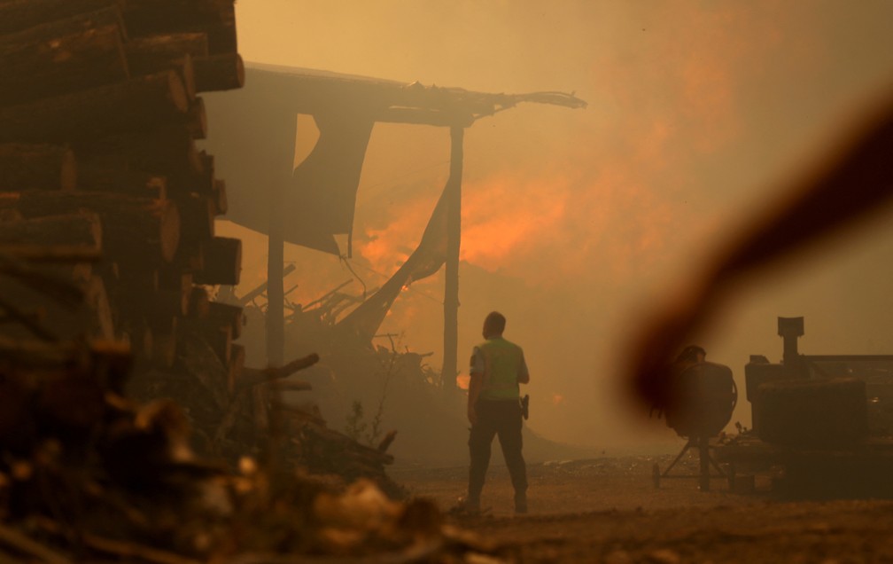 Uma pessoa observa um incêndio em Leiria, Portugal, no último dia 13 de julho. — Foto: REUTERS/Rodrigo Antunes