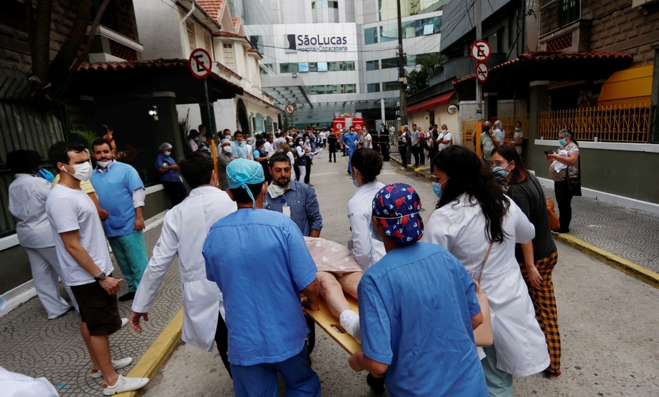 Equipe médica remove paciente de maca do Hospital São Lucas, em Copacabana, atingindo por incêndio
