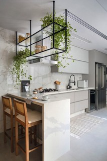 Na cozinha projetada pelo escritório Beta Arquitetura, os armários clean e o módulo suspenso de serralheria são da Dell Anno
