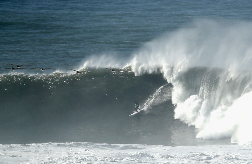 Surfista enfrenta mar agitado em Half Moon Bay, na Califórnia, nos EUA, na segunda-feira (17) — Foto: Ezra Shaw / Getty Images / AFP