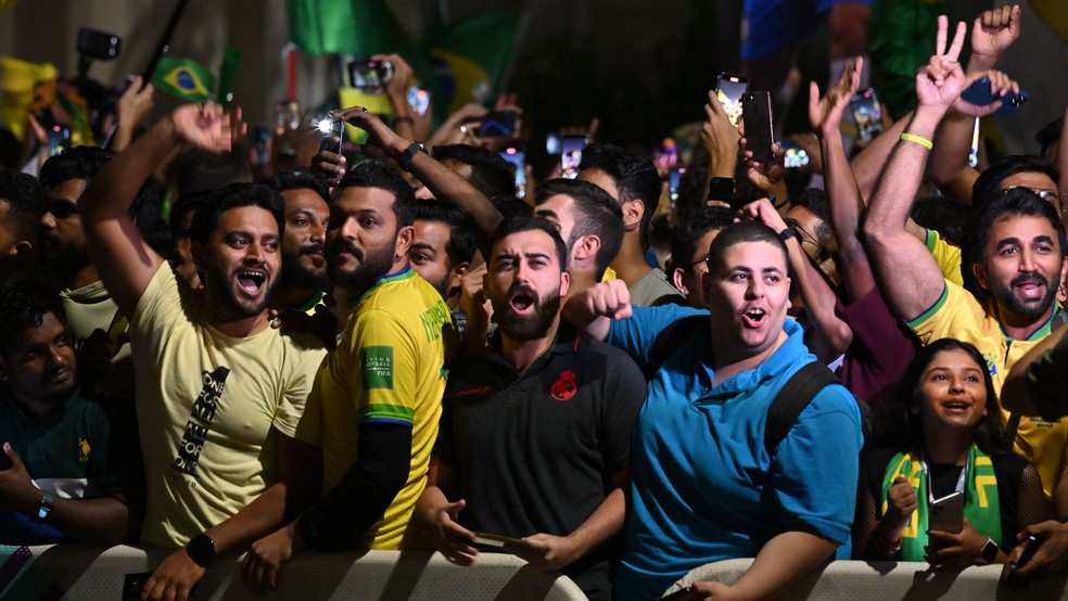 Brasileiros, indianos e paquistaneses aglomerados em frente ao hotel da seleção, em Doha, Catar — Foto: Nelson Almeida/AFP