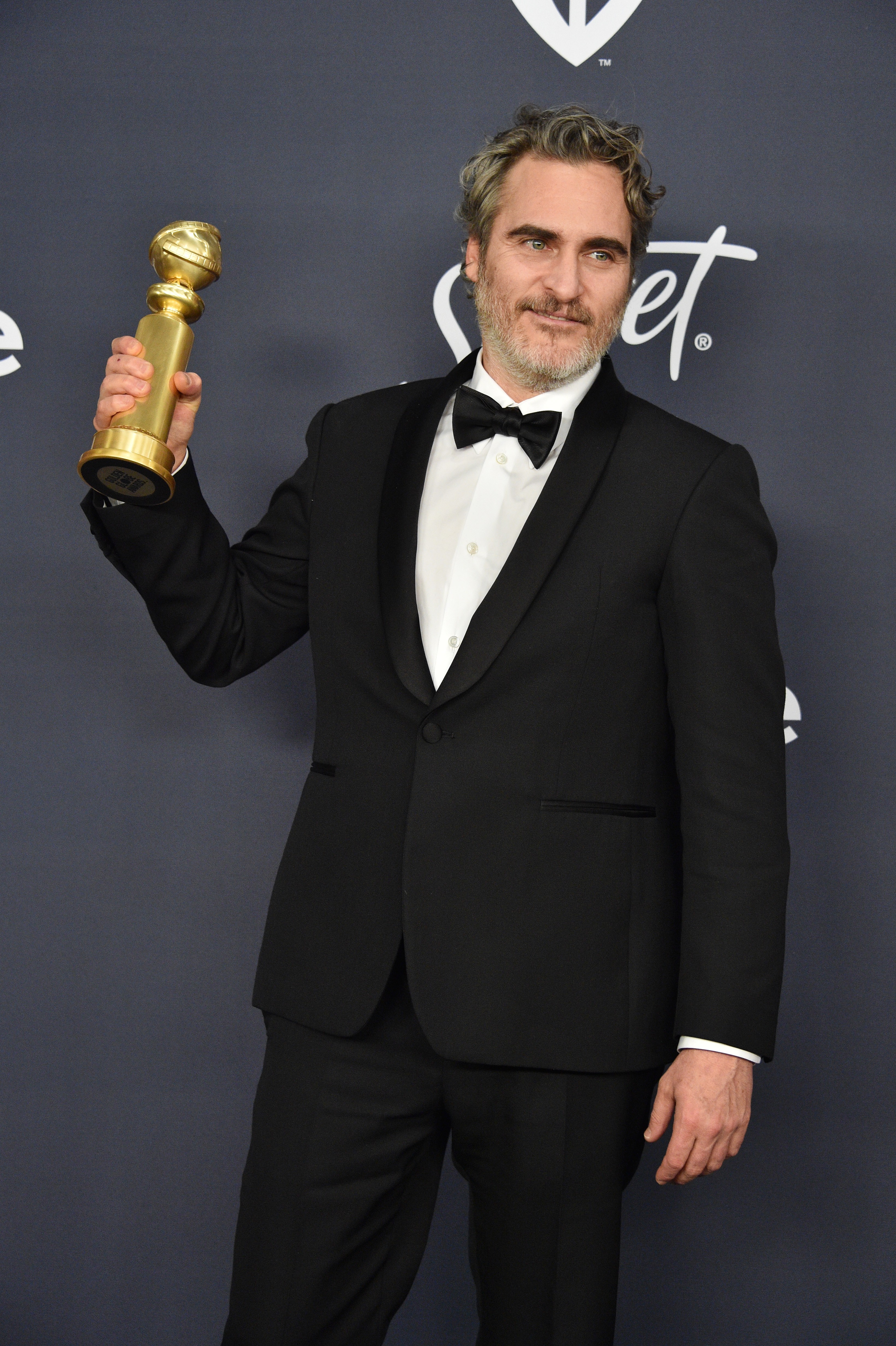 O ator Joaquin Phoenix com a estatueta do Globo de Ouro vencida por ele na categoria de Melhor Ator em Drama por seu trabalho em Corinha (2019) (Foto: Getty Images)