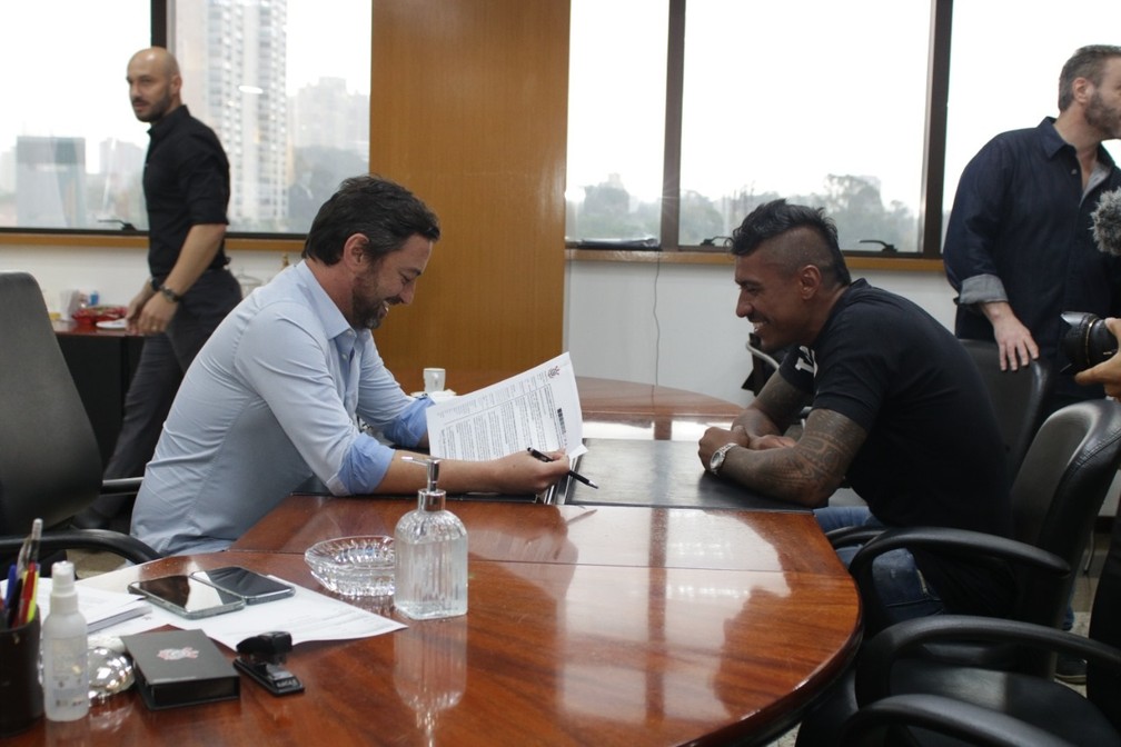 Duilio Monteiro Alves, presidente do Corinthians, e Paulinho assinando contrato — Foto: Agência Corinthians