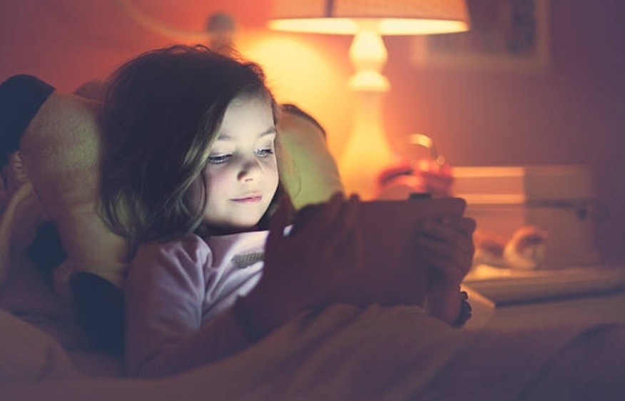 Menina usando tablet na cama durante a noite (Foto: Getty Images)