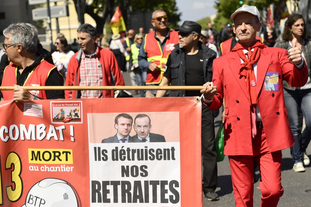 Manifestantes seguram uma placa dizendo "eles estão destruindo nossa aposentadoria", em um protesto em Marselha, na França, nesta quarta (1º), Dia do Trabalho. — Foto: Christophe Simon/AFP