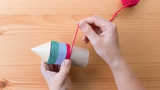 Passo 3: Cole as lãs coloridas em volta do rolo de papel higiênico.  — Foto: Tamy Rente