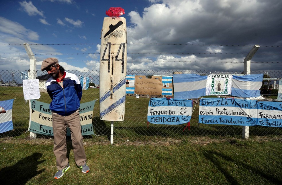 Homem estende faixas em apoio aos 44 tripulantes do submarino argentino ARA San Juan, desaparecido no mar, em frente à Base Naval da Argentina em Mar del Plata (Foto: Marcos Brindicci/Reuters)