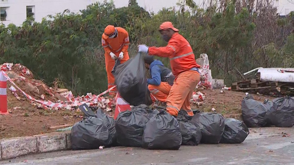 Equipe da SLU foram acionadas para retirar a carga que tombou na pista — Foto: Reprodução / TV Globo