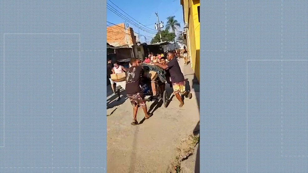 Saque da carga ocorreu na favela Kelson's. Houve quem usasse carrinho de mão para transportar a carga — Foto: Reprodução
