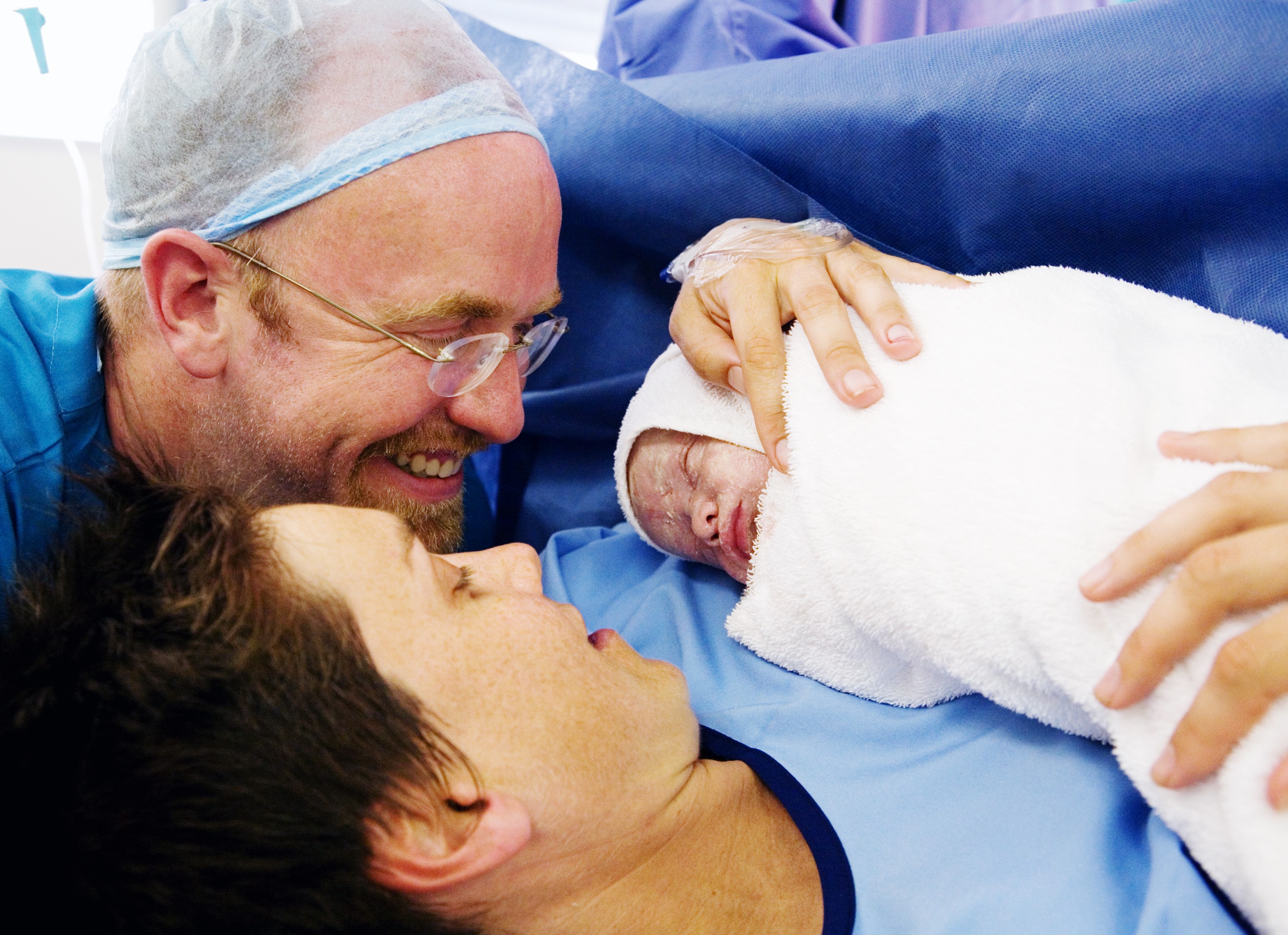 Mãe e pai veem recém-nascido pela primeira vez depois de uma cesárea (Foto: Getty Images)