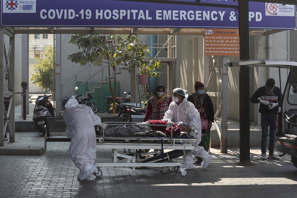 Profissionais de saúde entram com paciente em maca em um hospital para Covid-19 em Ahmedabad, na Índia, em 12 de janeiro de 2022 — Foto: Ajit Solanki/AP