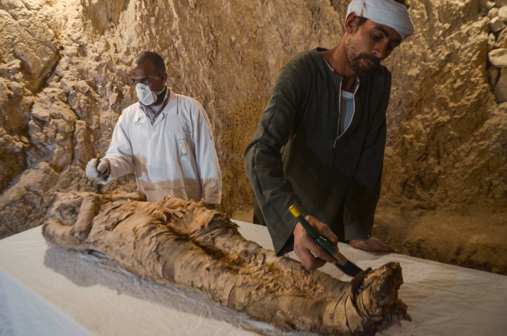 Arqueólogos restauram uma múmia encontrada em tumba na cidade egípcia de Luxor — Foto: Stringer/AFP