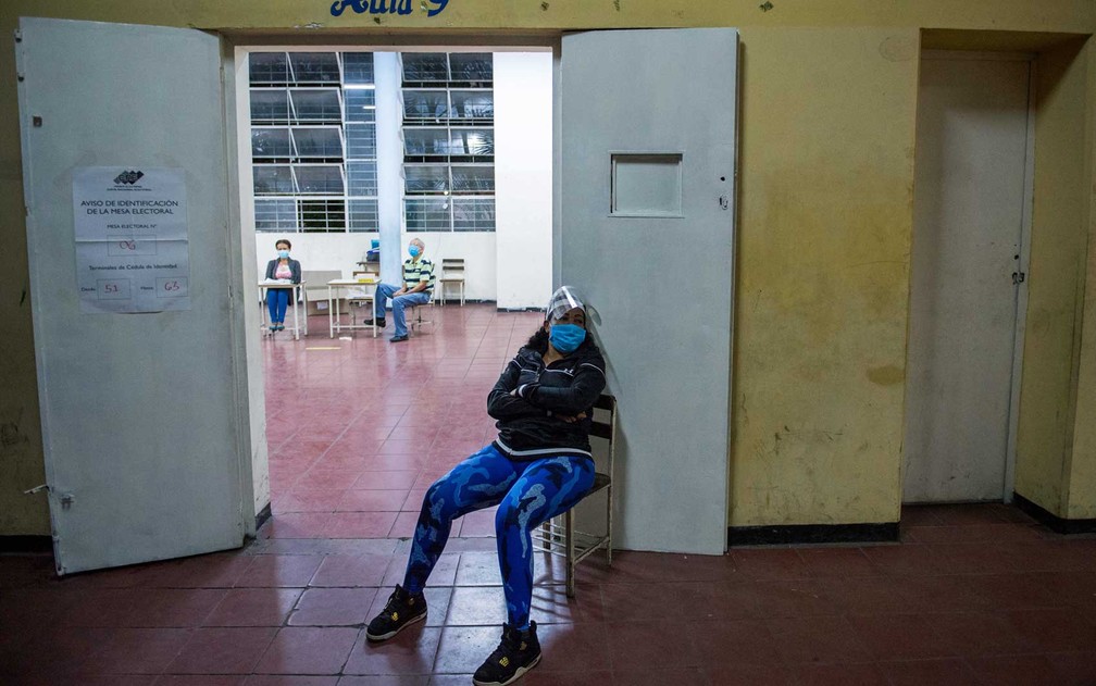 Servidora à espera de eleitores em uma escola em Caracas — Foto: Cristian Hernandez / AFP Photo