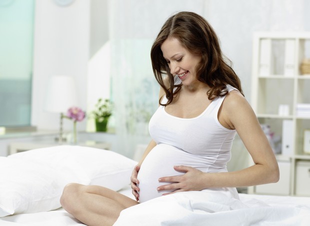 mulher grávida falando com o bebê na barriga (Foto: Thinkstock Photo)