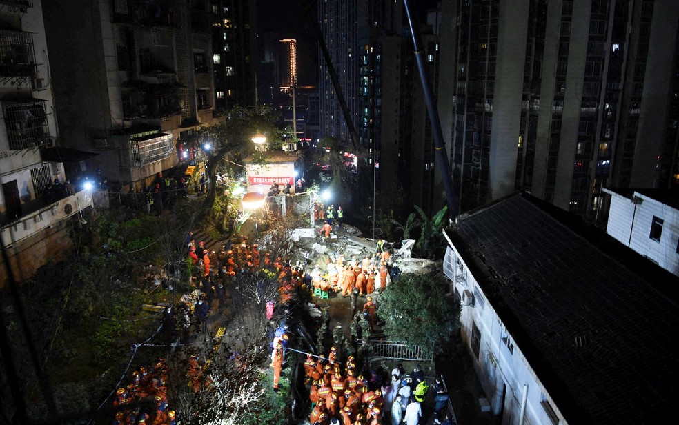 Bombeiros realizam resgate em local onde prédio desabou após explosão em Congqing, na China, na noite de sexta-feira (7) — Foto: cnsphoto via Reuters