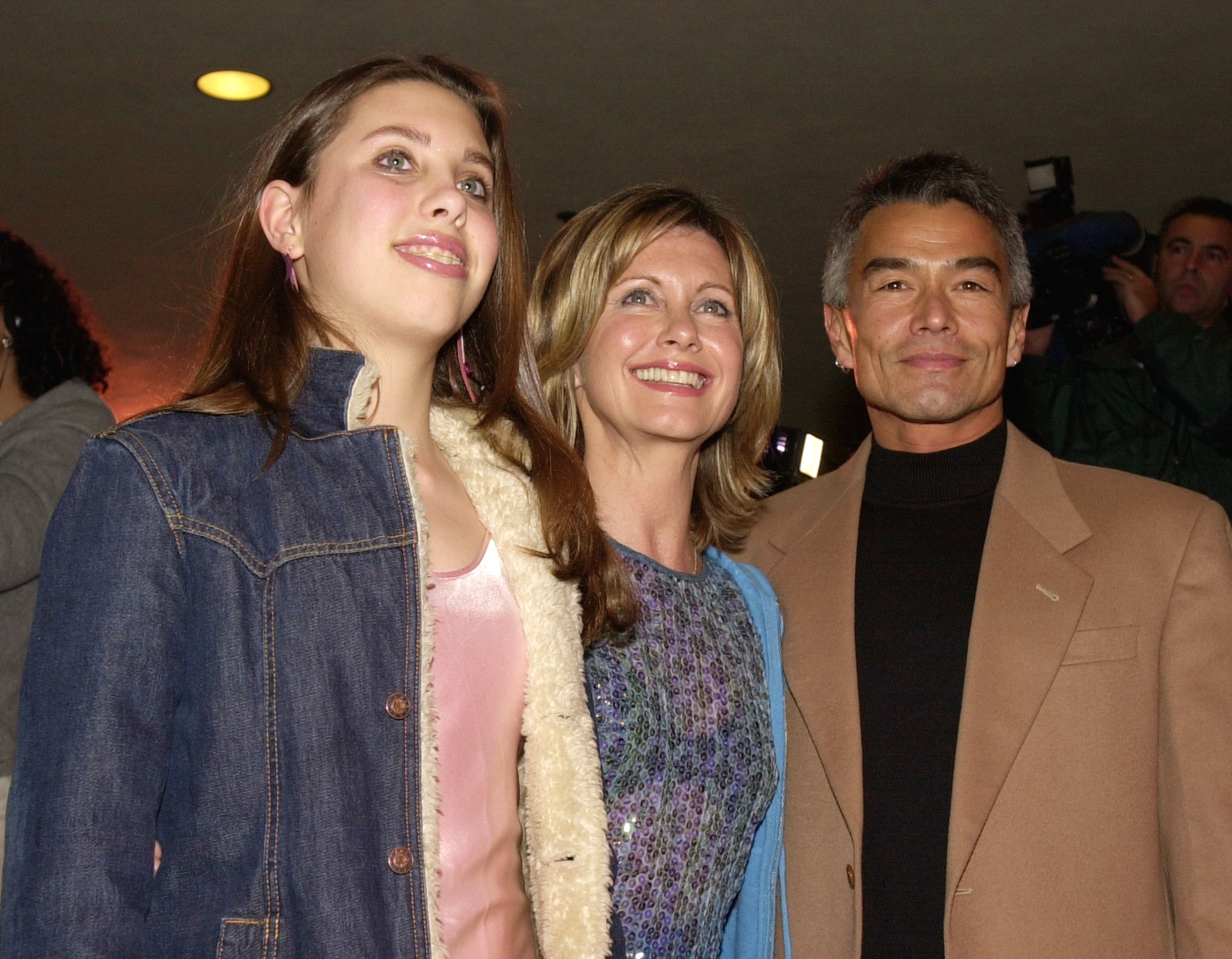 A atriz Olivia Newton-John com a filha Chloe e o cinegrafista Patrick McDermott em evento em Los Angeles em fevereiro de 2001, cerca de quatro anos antes dele desaparecer (Foto: Getty Images)