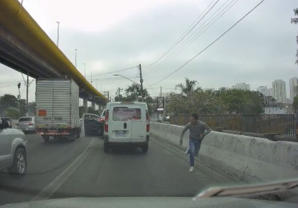 Ladrão corre ao roubar carro branco na Avenida do Estado, em SP, nesta quarta-feira (28). — Foto: Reprodução/TV Globo