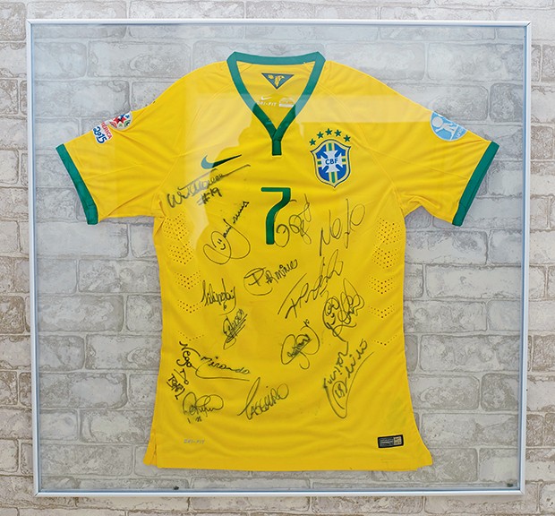  A camisa com autógrafos de jogadores da seleção foi presente do atacante Douglas Costa  (Foto:  )