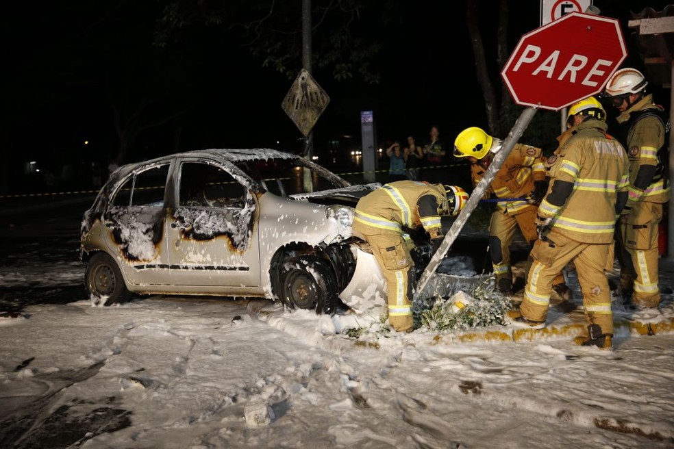 Bombeiros ao fazer procedimento para apagar incêndio em carro (Foto: Corpo de Bombeiros/Divulgação)