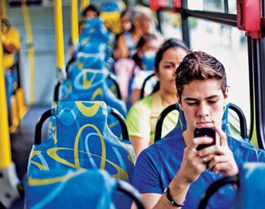 Jovem usa celular durante trajeto de ônibus: 250,8 milhões de linhas ativas (Foto: Reprodução Internet)