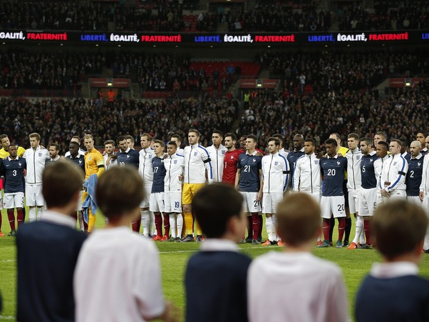 Integrantes das seleções da França e Inglaterra se alinham em campo para cantar a Marselhesa antes do início de amistoso no estádio de Wembley, em Londres, na terça (17) (Foto: AFP Photo/Adrian Dennis)