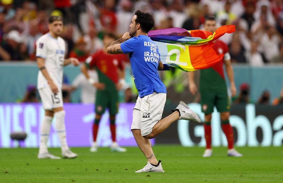 Espectador invade o campo de Portugal x Uruguai com bandeira LGBTQIAP+ — Foto: REUTERS/Kai Pfaffenbach