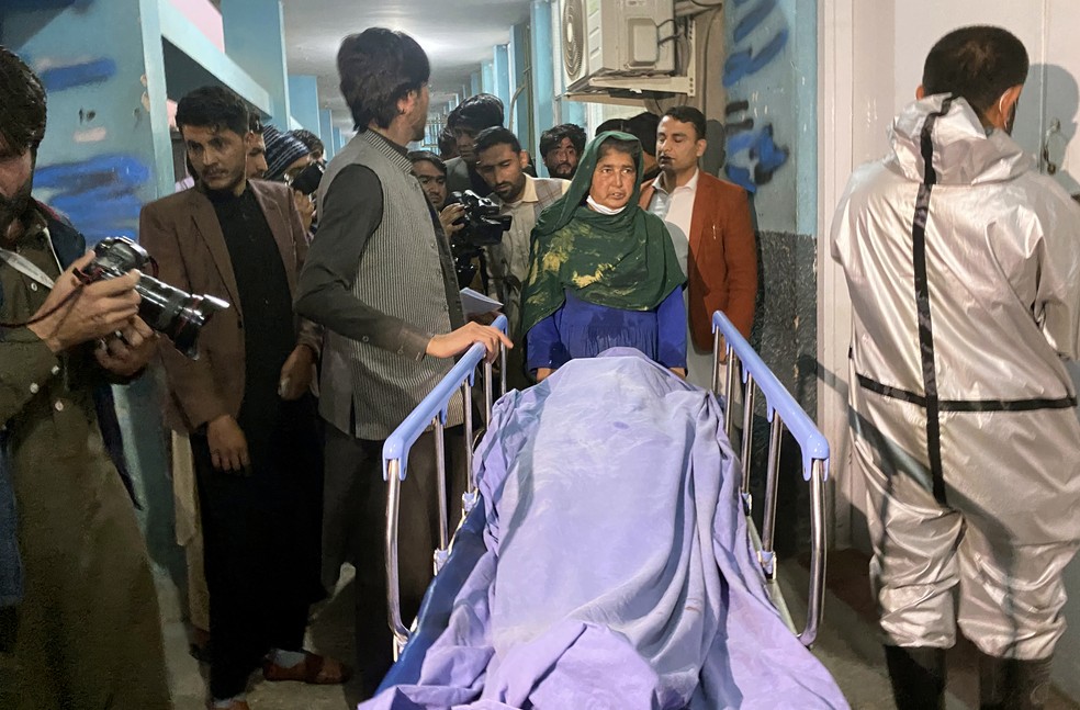 Afegãos carregam o corpo de uma das três vítimas de ataques a tiros em Jalalabad, no Afeganistão, em 2 de março de 2021 — Foto: Sadaqat Ghorzang/AP