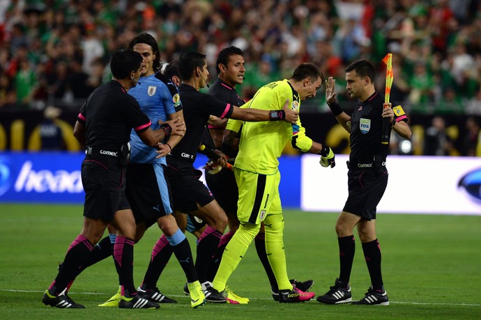 Cavani e Muslera peitam o trio de arbitragem depois de México x Uruguai (Foto: REUTERS/Joe Camporeale-USA TODAY Sports)