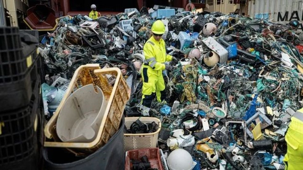 Tripulação da Ocean Cleanup separando o plástico no convés de um navio após uma extração de lixo — Foto: THE OCEAN CLEANUP