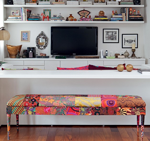 Nas costas do sofá da sala de televisão, bancada de trabalho projetada por Maristela Gorayeb e banco Or, todo de patchwork, de Ana Morelli