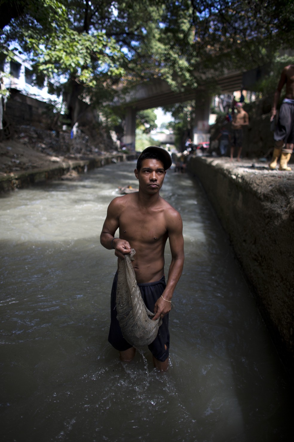 O jovem Douglas 'garimpa' o Rio Guaire, em Caracas (Foto: Ariana Cubillos)