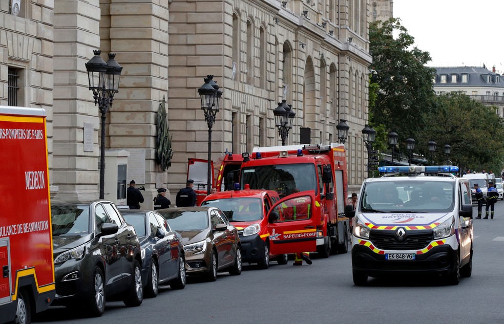 Polícia e bombeiros franceses são fotografados na entrada da sede da polícia em Paris, na França, nesta quinta-feira (3)  — Foto: Philippe Wojazer/ Reuters