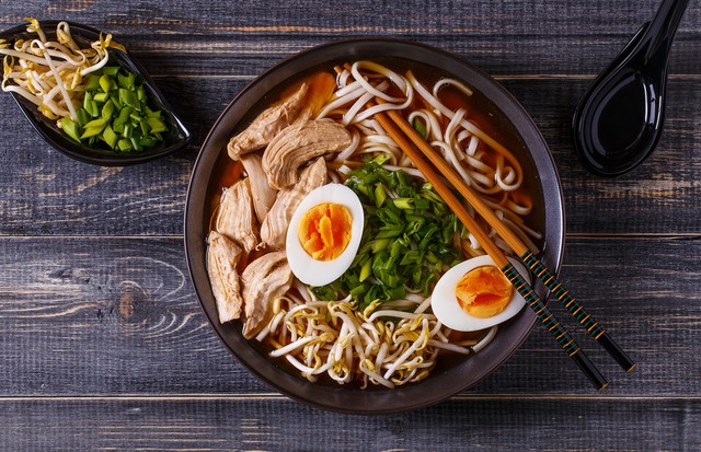 Japanese ramen soup with chicken, egg, chives and sprout on dark wooden background. (Foto: Getty Images/iStockphoto)