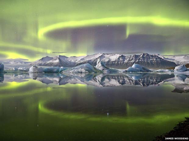 A aurora verde e vívida que cruza o céu noturno islandês é refletida na lagoa glacial de Vatnajökull, no Parque Nacional Jökulsarlon; a imagem tirada pelo fotógrafo britânico James Woodend ganhou o prêmio de Fotógrafo da Astronomia de 2014 (Foto: James Woodend)