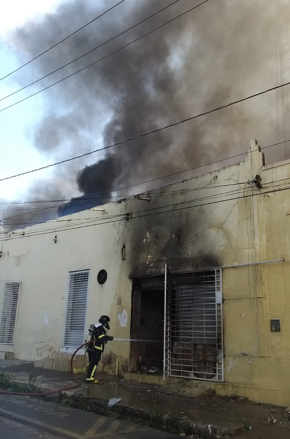 Bombeiro contendo chamas em loja que pega fogo no centro de Teresina — Foto: Samanta Araújo/ Rede Clube